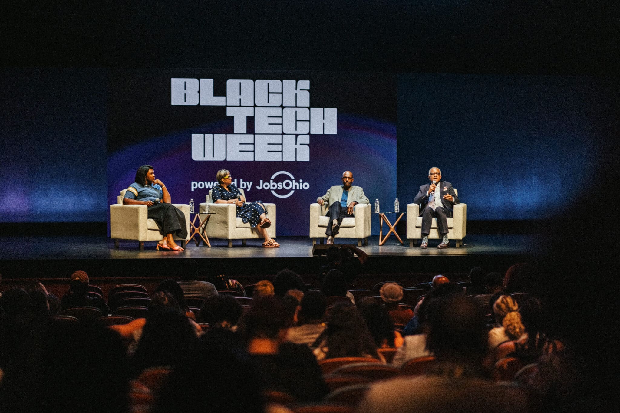 Four professionals speaking on stage at Black Tech Week 2025 in front of a large-scale LED tile presentation backdrop designed and created by Colortone